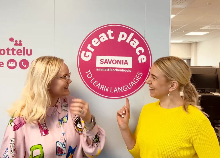 Kaksi henkilöä keskustelee Savonia-ammattikorkeakoulun tiloissa.